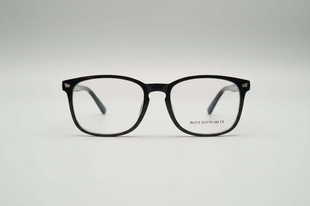 A pair of square-frame eyeglasses with a glossy black acetate frame and clear lenses, resting on a textured gray carpet.